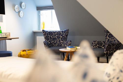 a living room with two chairs and a table at Ual Öömrang Wiartshüs in Norddorf