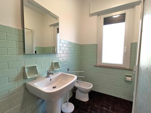 een badkamer met een wastafel en een toilet bij Appartamento Dolcefarniente in Lucrezia