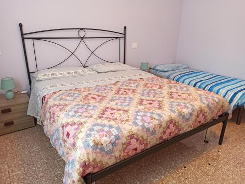 een slaapkamer met een bed met een quilt bij Appartamento Dolcefarniente in Lucrezia