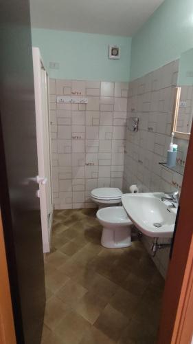 baño con 2 aseos y lavamanos en Casa Vacanza Baja Sardinia, en Baja Sardinia