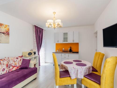 a living room with a table and chairs and a kitchen at Pensiunea Casuta cu Trandafiri 2 in Slănic