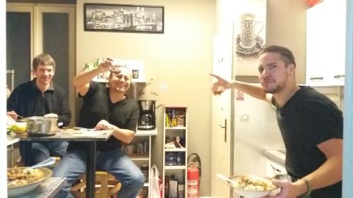 a group of three men standing in a kitchen at Hurricane Hostel in Split