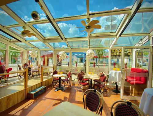 a conservatory with tables and chairs in a restaurant at Meister BÄR HOTEL Fichtelgebirge in Marktredwitz