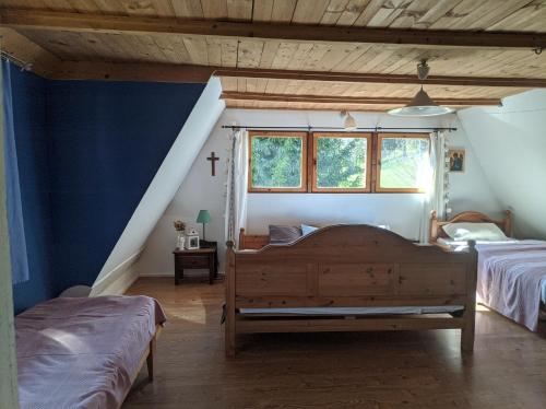 a bedroom with two beds and a blue wall at Pokoje u Agnieszki in Dwernik
