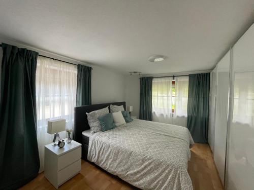 1 dormitorio con 1 cama grande y cortinas verdes en Ferienwohnung Siglreitmaier 2, en Chieming