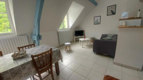 a living room with a table and a couch at Appartement ESTAUBE Résidence les 3 cirques in Gèdre
