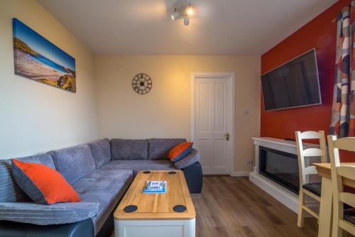 a living room with a blue couch and a table at Suil Na Mara Studio in Lochinver