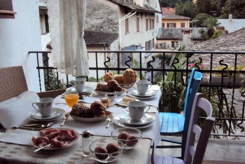 a table with plates of food on a balcony at bb chiavenna centro storico in Chiavenna