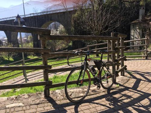 a bike parked next to a fence with a bridge at bb chiavenna centro storico in Chiavenna