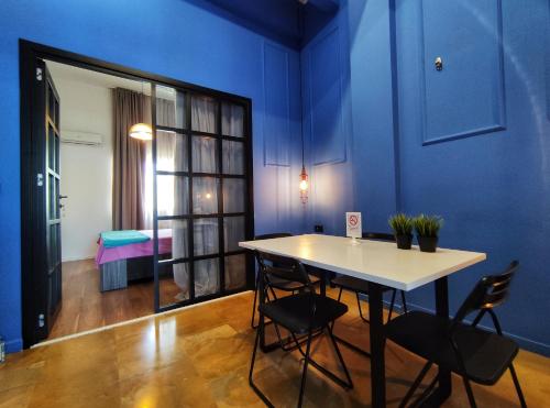 een kamer met een tafel en stoelen en een blauwe muur bij Luxury Apartments Aristotelous in Thessaloniki