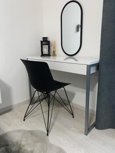 a desk with a black chair and a mirror at Villa Franko Baška Voda in Baška Voda