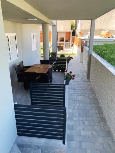 a patio with a wooden table and chairs and a table and chairsktop at Villa Franko Baška Voda in Baška Voda