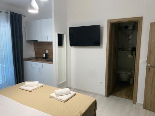a room with a bed and a kitchen with a television at Villa Franko Baška Voda in Baška Voda