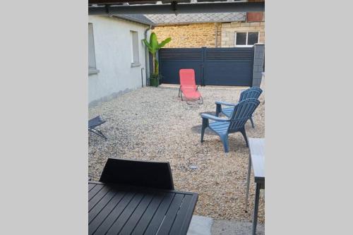 a patio with two chairs and a laptop on it at Le Petit Concise à 20mn du Mont Saint Michel in Saint-James