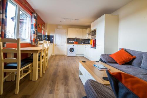 a kitchen and living room with a table and a couch at Suil Na Mara Studio in Lochinver
