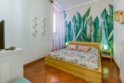 1 dormitorio con 1 cama con un mural tropical en la pared en Fiore di Roma - Campo de' Fiori en Roma