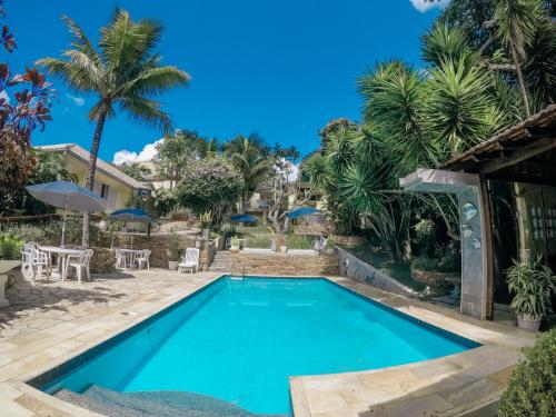 a swimming pool in a resort with palm trees at 3 Palmeiras Guest Lounge in Miguel Pereira