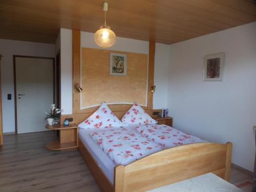 um quarto com uma cama com almofadas vermelhas e brancas em Ferienwohnung Dimpfl-Stad´l Fam. Lemberger em Lohberg