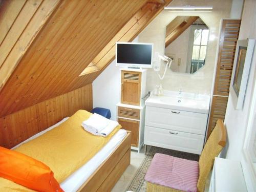a small bedroom with a bed and a sink at Ostsee Hotel-Pension An der Lindenallee in Bad Doberan