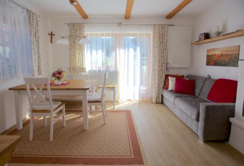 sala de estar con sofá, mesa y comedor en Ferienwohnung Maria, en Ebbs