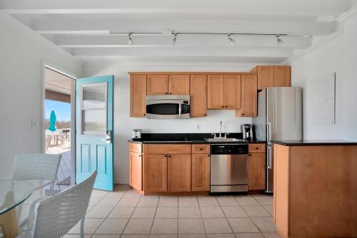 a kitchen with wooden cabinets and a stainless steel refrigerator at Driftwood Resort on the Ocean in Montauk