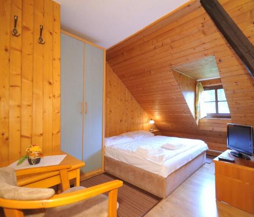 1 dormitorio con 1 cama en una habitación de madera en Penzion u Rudolfa, en Liptovský Ján