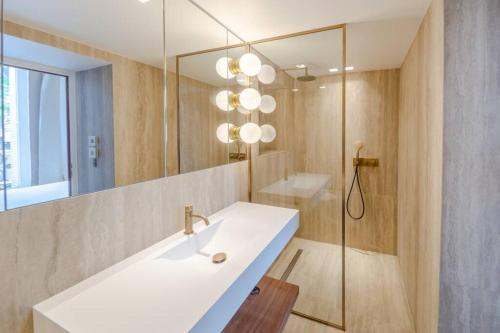 une salle de bain avec un lavabo et un miroir dans l'établissement Appartement de standing 2 - tour Eiffel/Invalides, à Paris