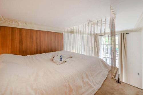 un lit blanc dans une chambre avec une fenêtre dans l'établissement Appartement de standing 2 - tour Eiffel/Invalides, à Paris