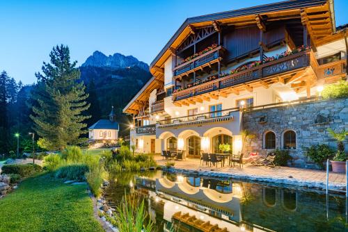 a building with a lake in front of it at Sunneschlössli Tannheimer Tal in Nesselwängle