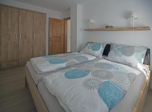 una camera con due letti con coperte bianche e blu di Ferienwohnung Maria a Ebbs