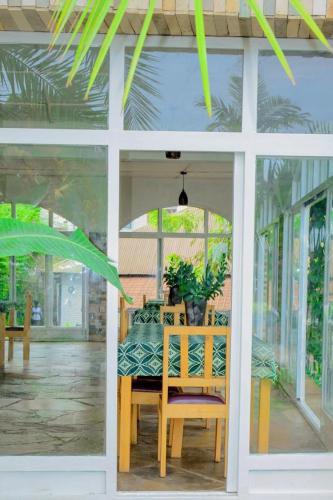 a dining room with a table and chairs in a house at Palm garden Resort in Gisenyi