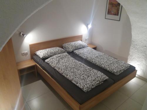 una piccola camera da letto con un letto in una stanza di Haus Möltner - Apartment 1927 a Caldaro