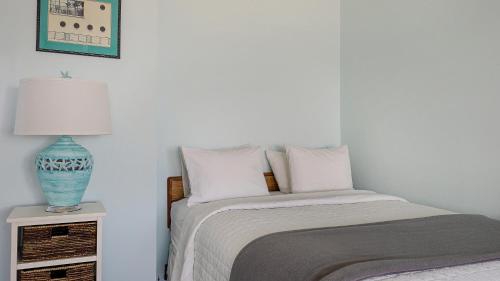 a bedroom with a bed and a vase on a night stand at Sea Crest in Amagansett