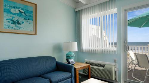 a living room with a blue couch and a view of the ocean at Sea Crest in Amagansett