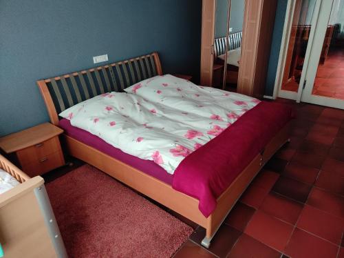 a bedroom with a bed with a pink blanket on it at Monteurwohnung Rhede No 1 im Erdgeschoss in Rhede