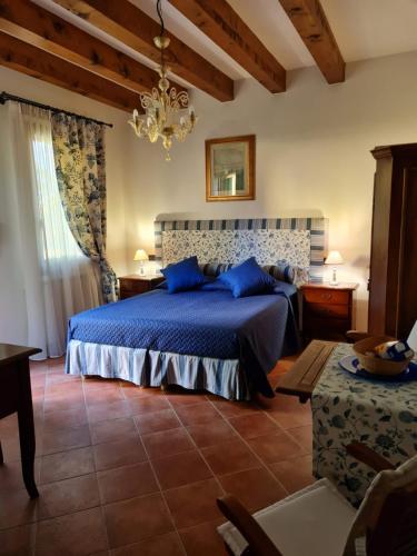 a bedroom with a blue bed and a chandelier at Casa Pianta in Cavallino-Treporti