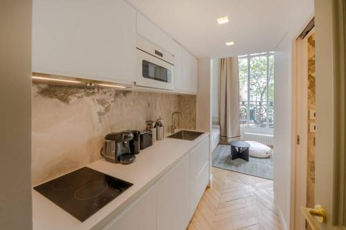 une cuisine avec un évier et un plan de travail dans l'établissement Appartement de standing 3 - tour Eiffel/Invalides, à Paris