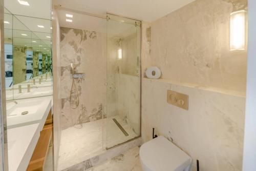 ein Bad mit einer Dusche, einem WC und einem Waschbecken in der Unterkunft Appartement de standing 3 - tour Eiffel/Invalides in Paris