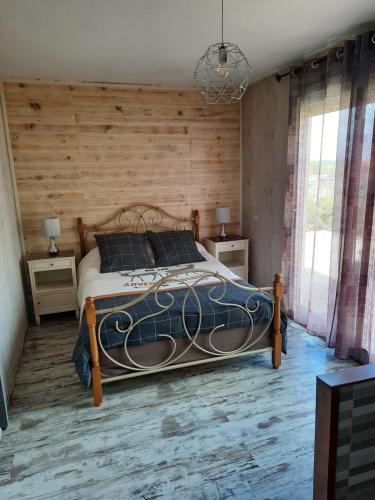 um quarto com uma cama e uma parede de madeira em ô bout d'la Motte em Voillecomte