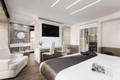 a bedroom with a bed and a desk with a television at Francisco I Boutique in Madrid