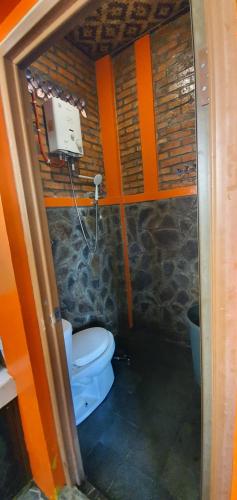 a small bathroom with a toilet and a phone at Saung Orange Village in Bogor