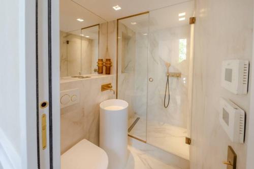 une salle de bain blanche avec douche et toilettes dans l'établissement Appartement de standing 4 - tour Eiffel/Invalides, à Paris