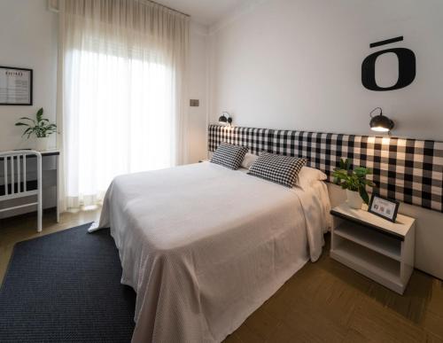 a bedroom with a bed with a checkered wall at Hotel Aplo - Breakfast Experience in Cervia