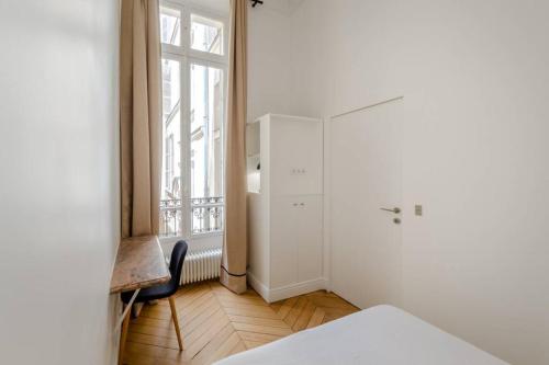 Zimmer mit einem Kühlschrank, einem Stuhl und einem Fenster in der Unterkunft Appartement de standing 5 - tour Eiffel/Invalides in Paris