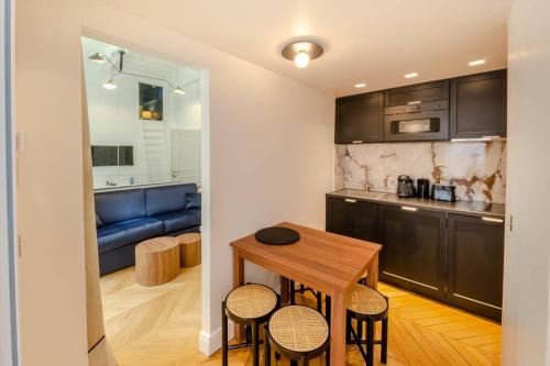 une cuisine et une salle à manger avec une table et des chaises dans l'établissement Appartement de standing 5 - tour Eiffel/Invalides, à Paris