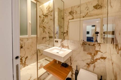 ein Bad mit einem Waschbecken und einem Spiegel in der Unterkunft Appartement de standing 5 - tour Eiffel/Invalides in Paris