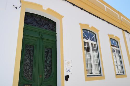 a green door on a white building with two windows at Cuba Real in Cuba