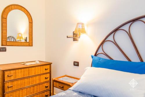 a bedroom with a bed and a dresser and a mirror at Almanzar - Residenze sul mare in Lampedusa