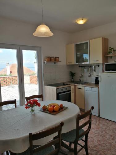 a kitchen with a table with a bowl of fruit on it at Olive Garden Accomodation in Savar