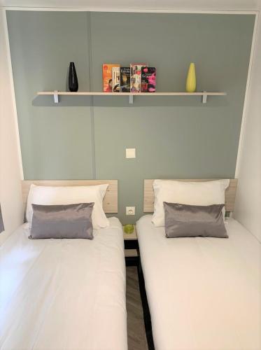 deux lits côte à côte dans une pièce dans l'établissement MOBILHOME 3 CH CAMPING 4*, à Onzain